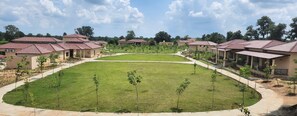 Una zona residencial con varias casas, un césped central y un camino pavimentado.