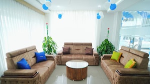Una sala de estar moderna con dos sofás, una mesa de centro y plantas decorativas.