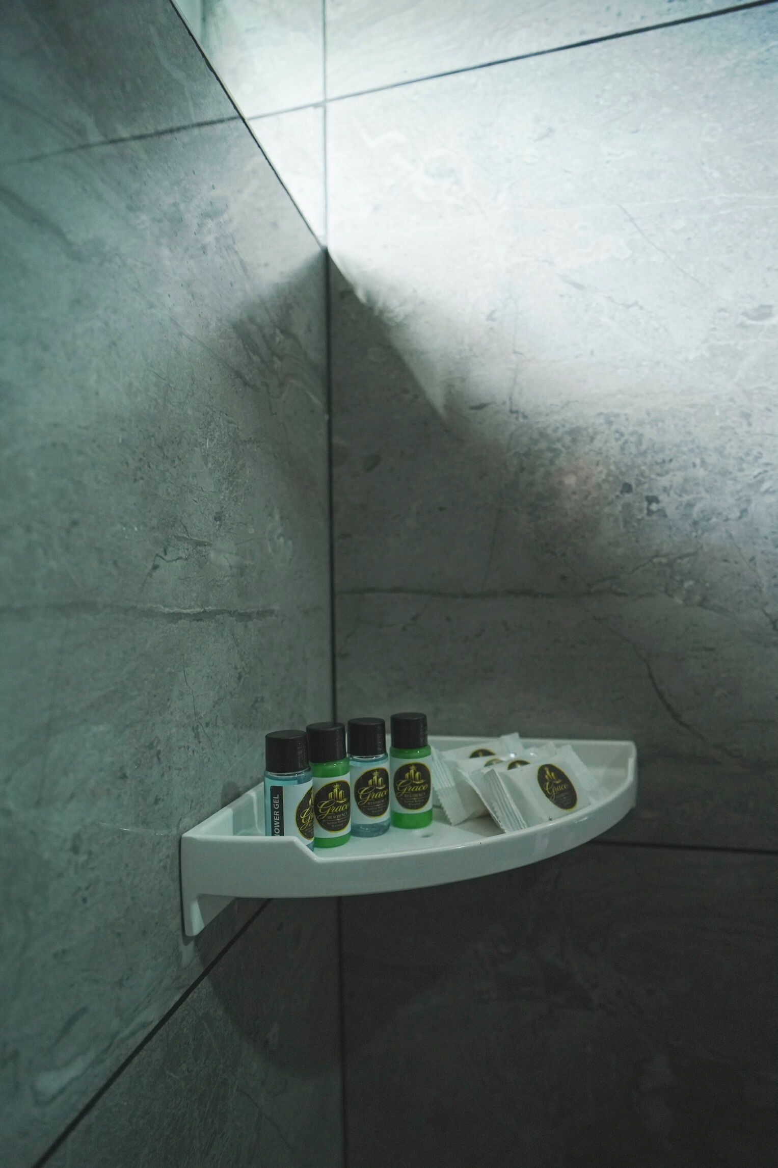 Un baño con un estante blanco que contiene varios artículos de tocador.