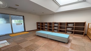 Una habitación con tragaluz, un banco y estantes con cestas.