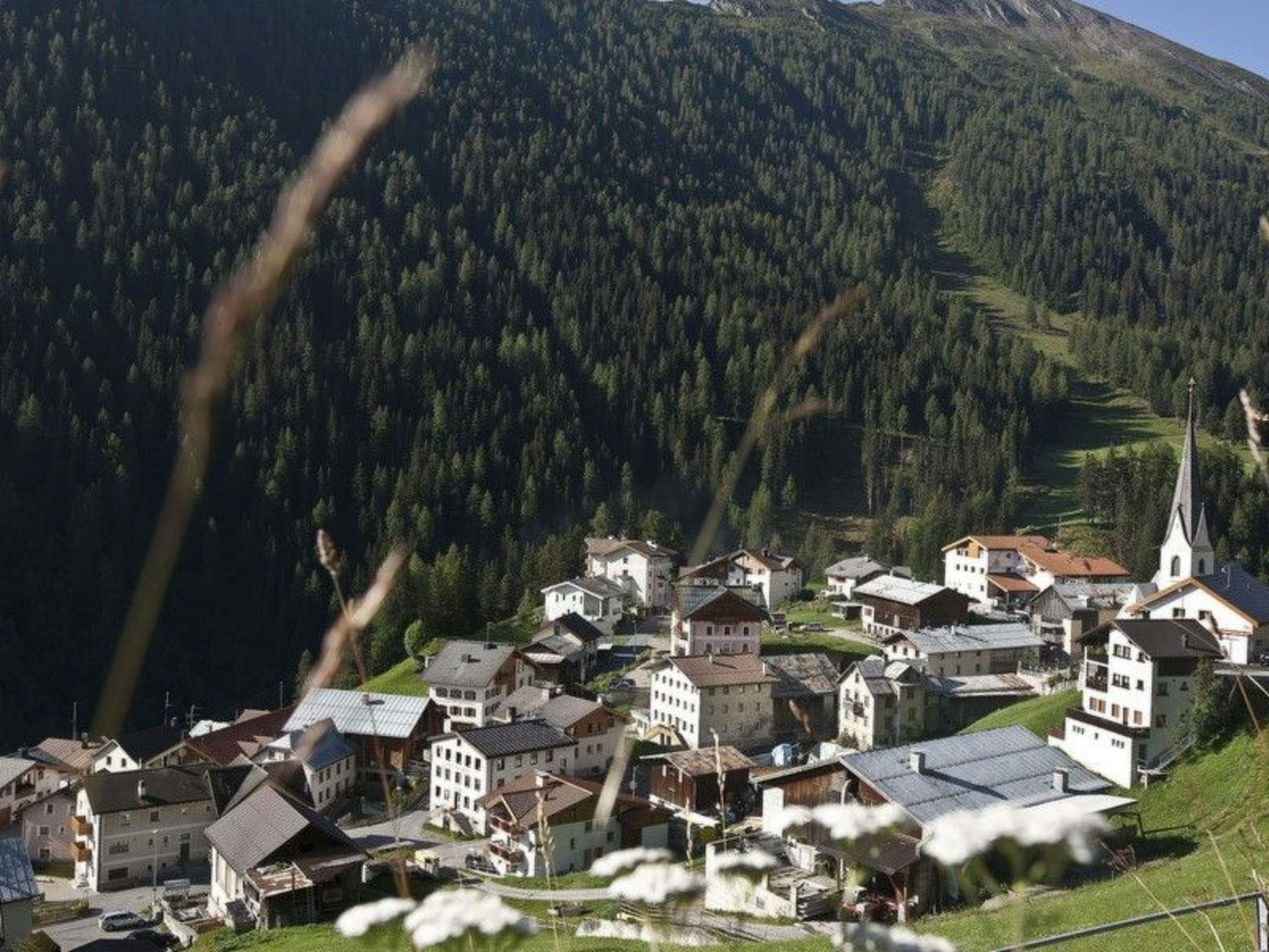 A mountainous village with traditional buildings and a church.