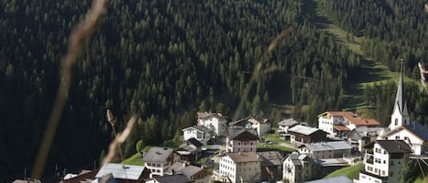 A mountainous village with traditional buildings and a church.