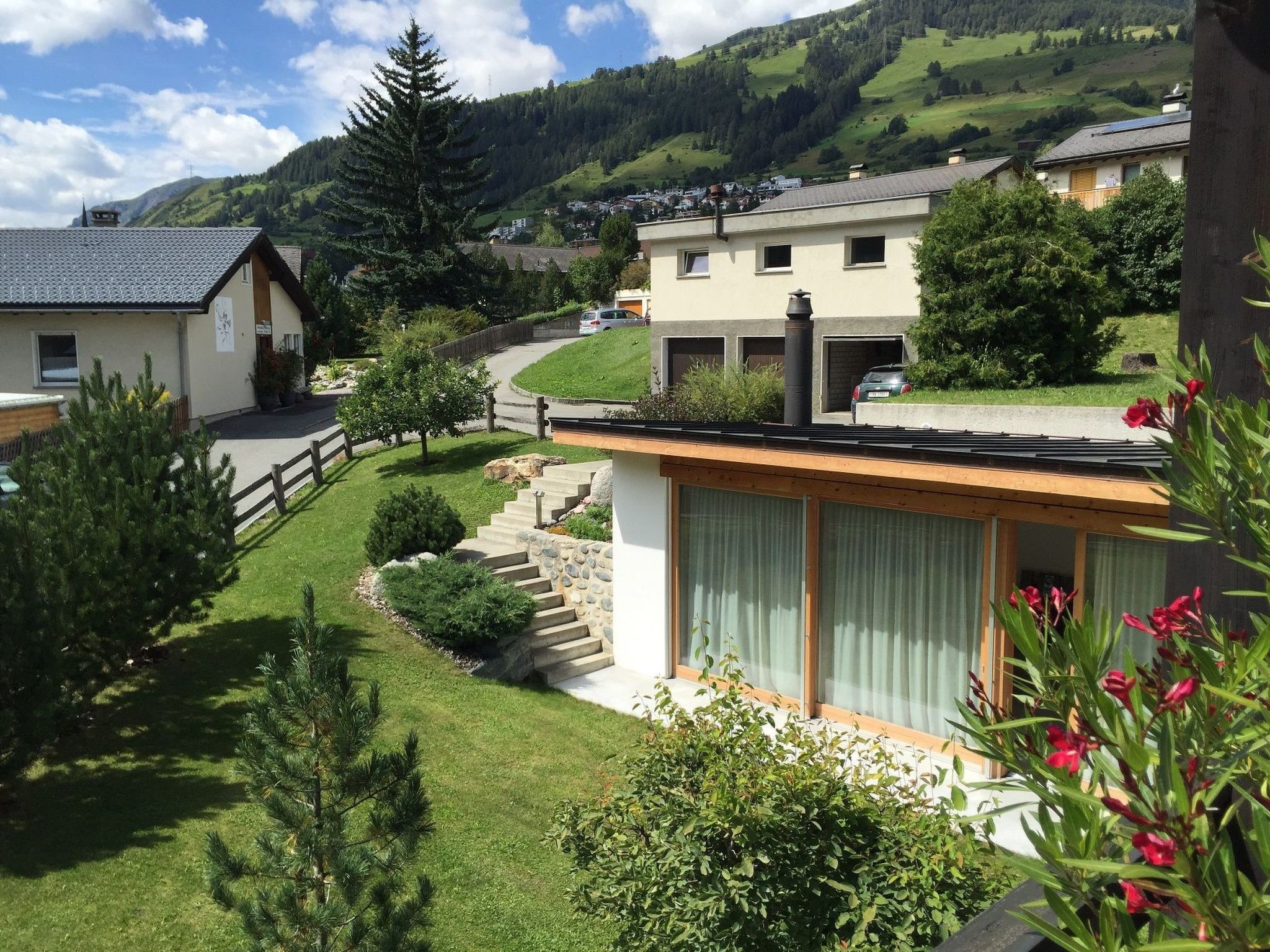 Ein Wohngebiet mit Häusern, einer asphaltierten Straße und einem Berg im Hintergrund.