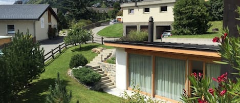 Ein Wohngebiet mit Häusern, einer asphaltierten Straße und einem Berg im Hintergrund.