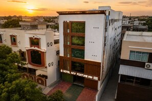 Un edificio moderno de hotel con un letrero llamativo que dice 'Hotel MV Fortune Inn'.