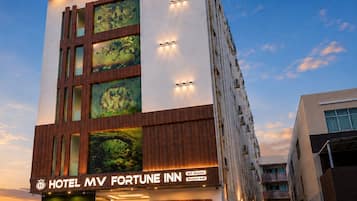A multi-story hotel with a modern facade, including a prominent sign for the Hotel MV Fortune Inn.