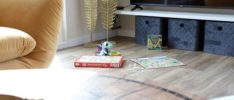A living room with a sofa, a television, and puzzle pieces on the floor.