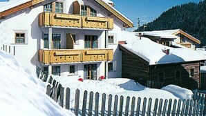 Un immeuble à plusieurs étages doté de balcons, entouré de neige.