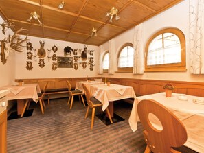 A restaurant interior with wooden paneling, multiple tables, and wall-mounted animal head decorations. - Appartements Lärchenhof, (Samnaun-Compatsch) by Interhome (Samnaun)