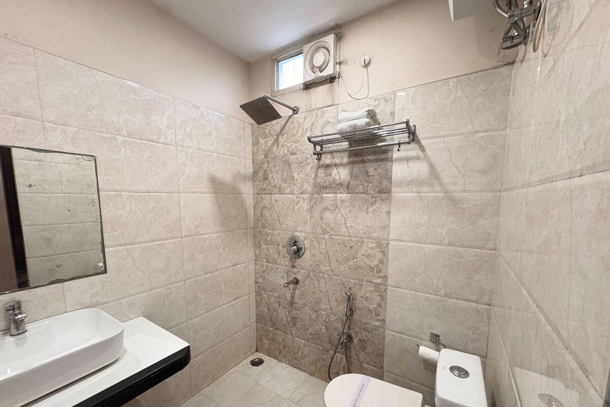 A bathroom with a sink, toilet, shower, and a towel rack.