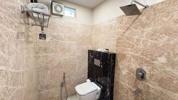 Un baño con inodoro, ducha y toallero.