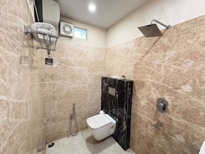 A bathroom with a toilet, a shower, and a towel rack.