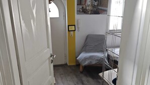 Ein schmaler Gang mit einem Bett und einer Tür.