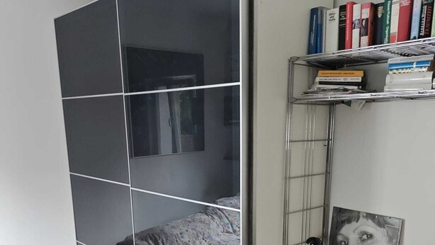 Ein Schlafzimmer mit einem Bett, einem Schreibtisch und einem Bücherregal.
