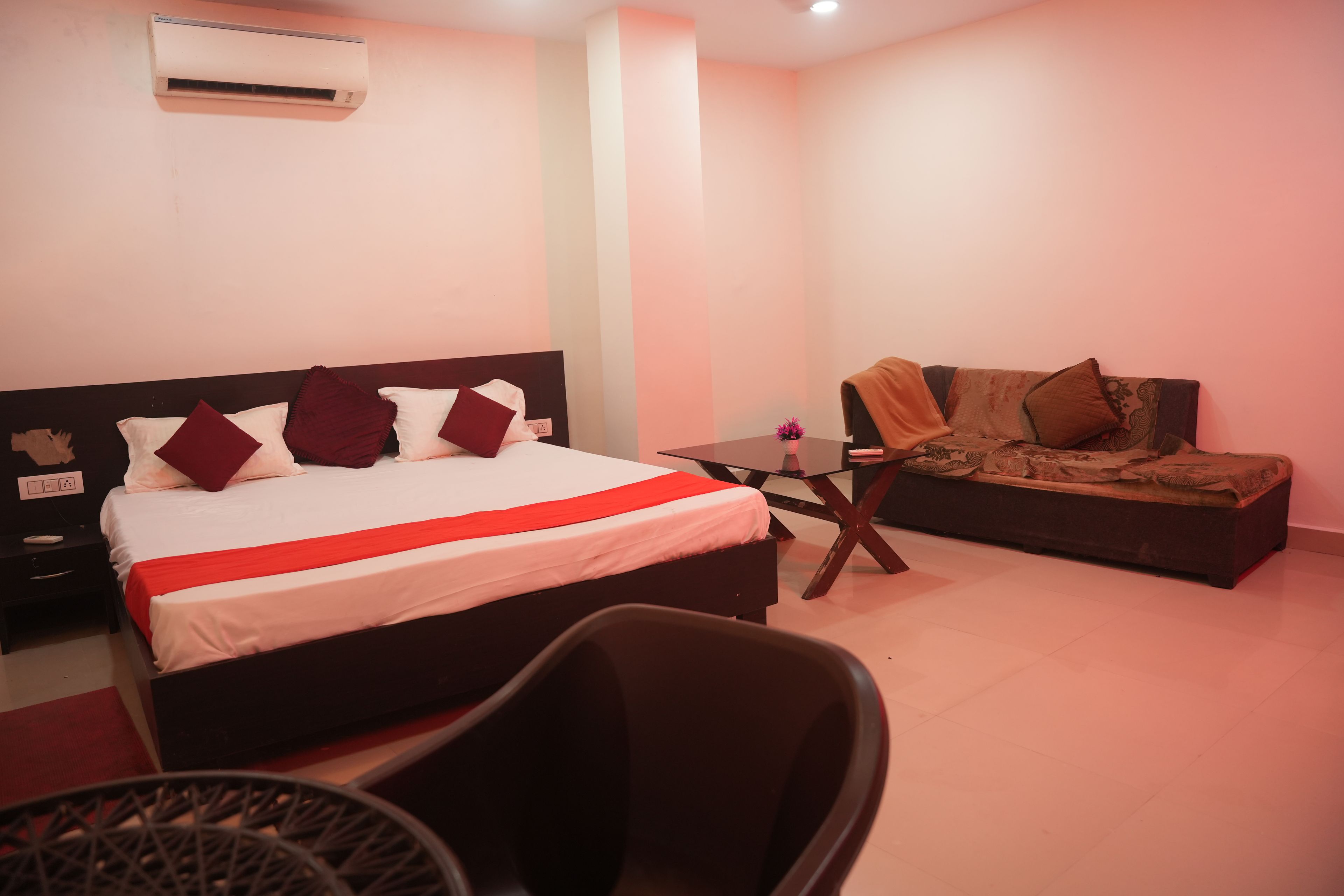 Una habitación de hotel con una cama, un sofá, una mesita y una silla.