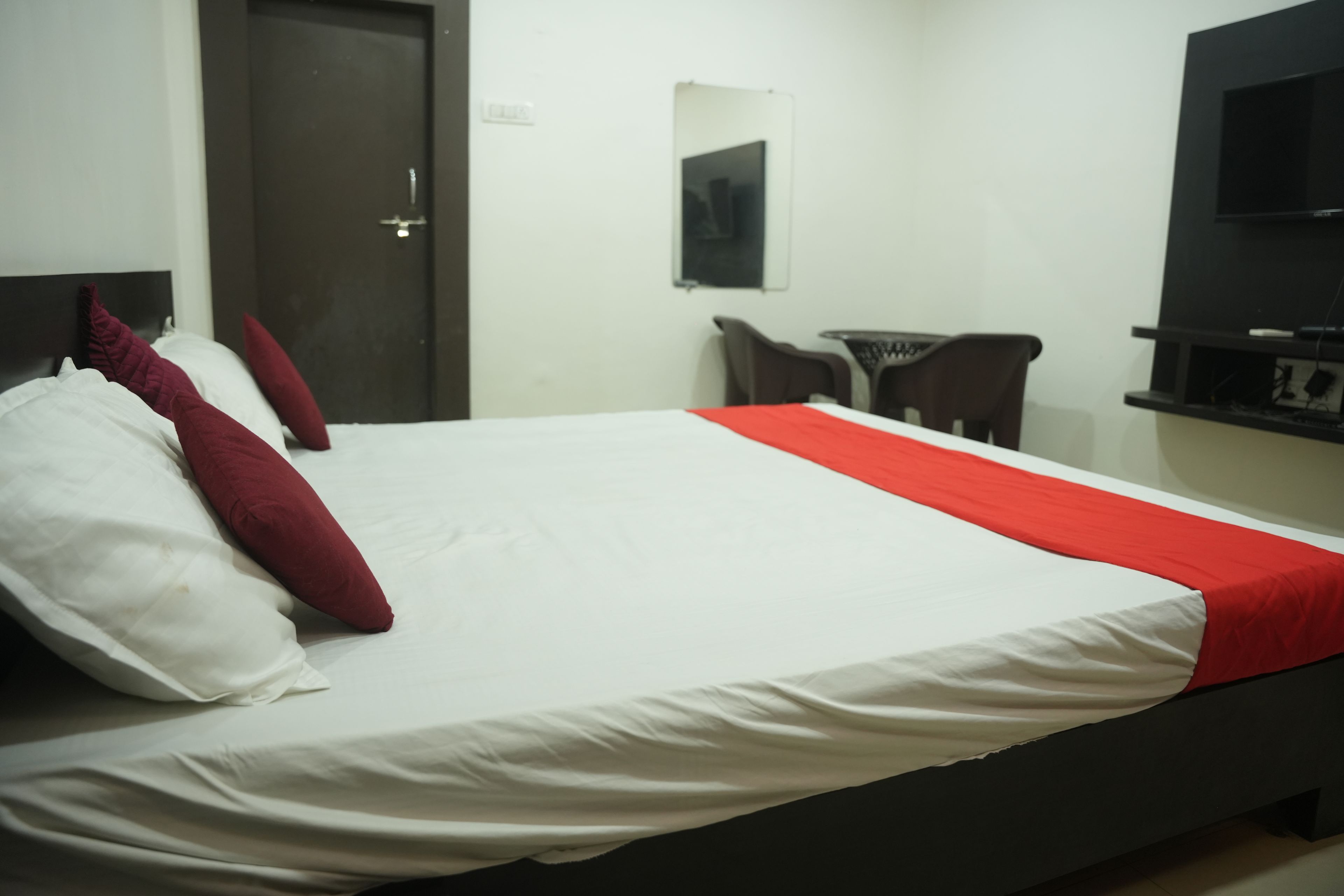 Una habitación de hotel con cama, una silla, una mesa y televisión.
