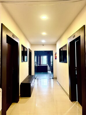 Un pasillo de hotel con puertas numeradas 207 y 208, que conduce a una escalera.