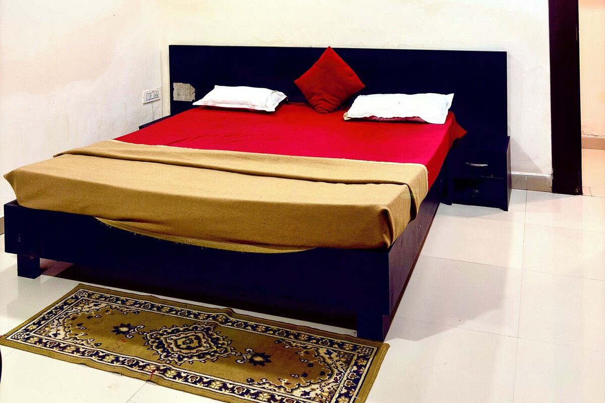 Un dormitorio con una cama, ventilador de techo, un cuadro y una alfombra.