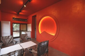A room with a large circular wall feature, a window, and a Coleman camping chair. - Keshiki Tatsukane | Vacation Rental for Large Groups: BBQ & Karaoke (富津市)