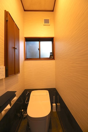 A small bathroom with a toilet, a window, and a cabinet. - Keshiki Tatsukane | Vacation Rental for Large Groups: BBQ & Karaoke (富津市)