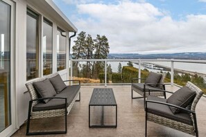 Un balcon avec des meubles d’extérieur, une vue sur un pont et des arbres.