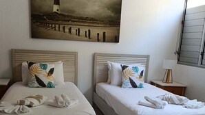 A hotel room with two beds, each with a pillow and rolled towels. - Great family holiday home at Magnetic Island where adventure and fun starts. (Nelly Bay)