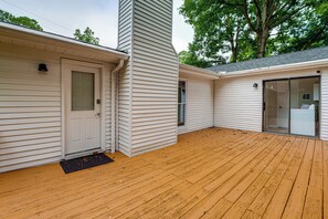 A house with a wooden deck, a garage door, and a covered entryway. - Kennesaw Home Near KSU & Lake Acworth (Kennesaw)