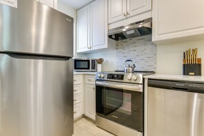 A modern kitchen with stainless steel appliances, including a refrigerator, microwave, oven, and dishwasher. - Relax, Recharge, Repeat: Hilton Head Resort Condo (Hilton Head Island)
