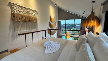 A bedroom with a bed, a balcony, and a view of the outdoors.