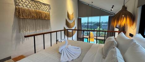 A bedroom with a bed, a balcony, and a view of the outdoors.