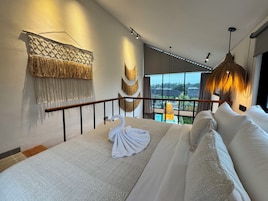 Quarto com cama, varanda e vista para o exterior.