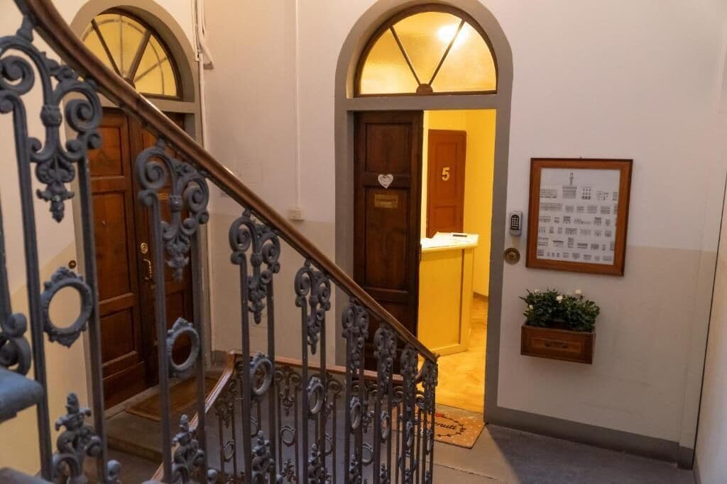 A staircase with ornate metal railings leading to a door marked with the number 5.