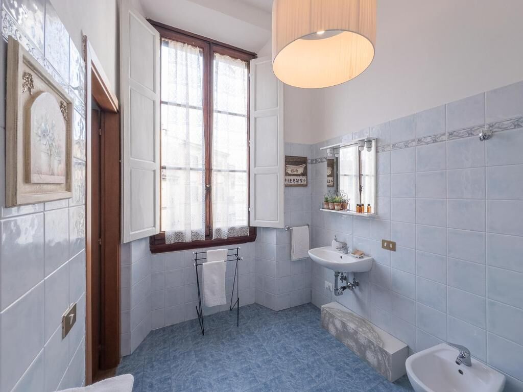 Un bagno con finestra, due lavabi, uno specchio e un porta asciugamani.