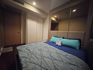 Ein Schlafzimmer mit Bett, Kleiderschrank und Spiegel.