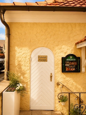 A building facade with a white door labeled 'Fahrad-Garage,' a sign for 'Ristorante Pias,' and a framed menu for 'Distelhauser.' - Hotel NeckarOase (Lauffen am Neckar)