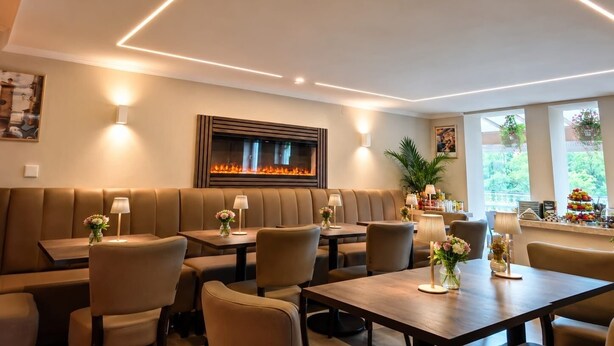 A modern dining area with a fireplace, seating arrangements, and ambient lighting.