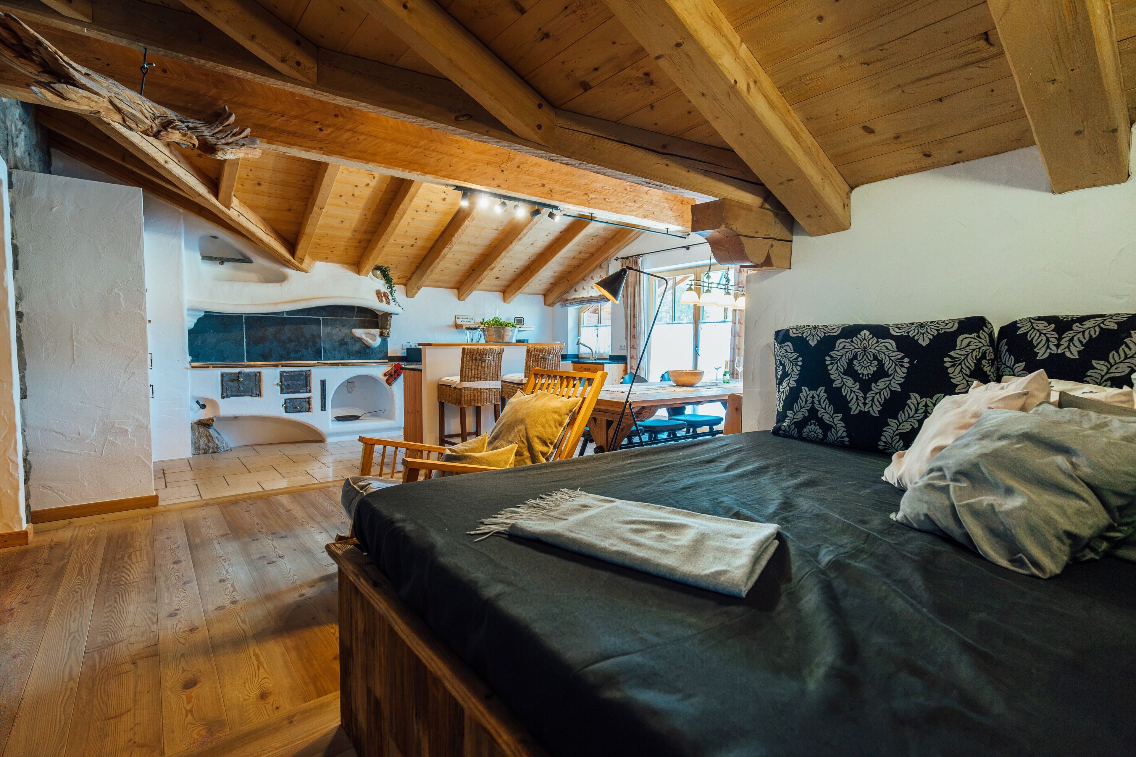 Ein gemütliches Zimmer mit einem Bett, einem Esstisch und einer Küchenzeile.
