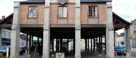 A building with a brick facade, large windows, and a covered entrance area.