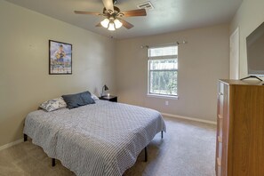 A bedroom with a bed, a ceiling fan, a window, and a dresser. - Extended East Tulsa Home w/ Fenced Yard (Tulsa)