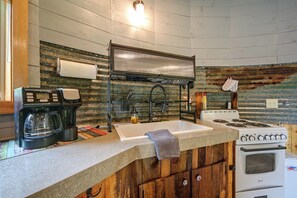 A kitchen with a coffee maker, sink, stove, and wooden cabinets. - Outdoor Oasis w/ Mtn Views! 5-Acre Augusta Getaway (Augusta)