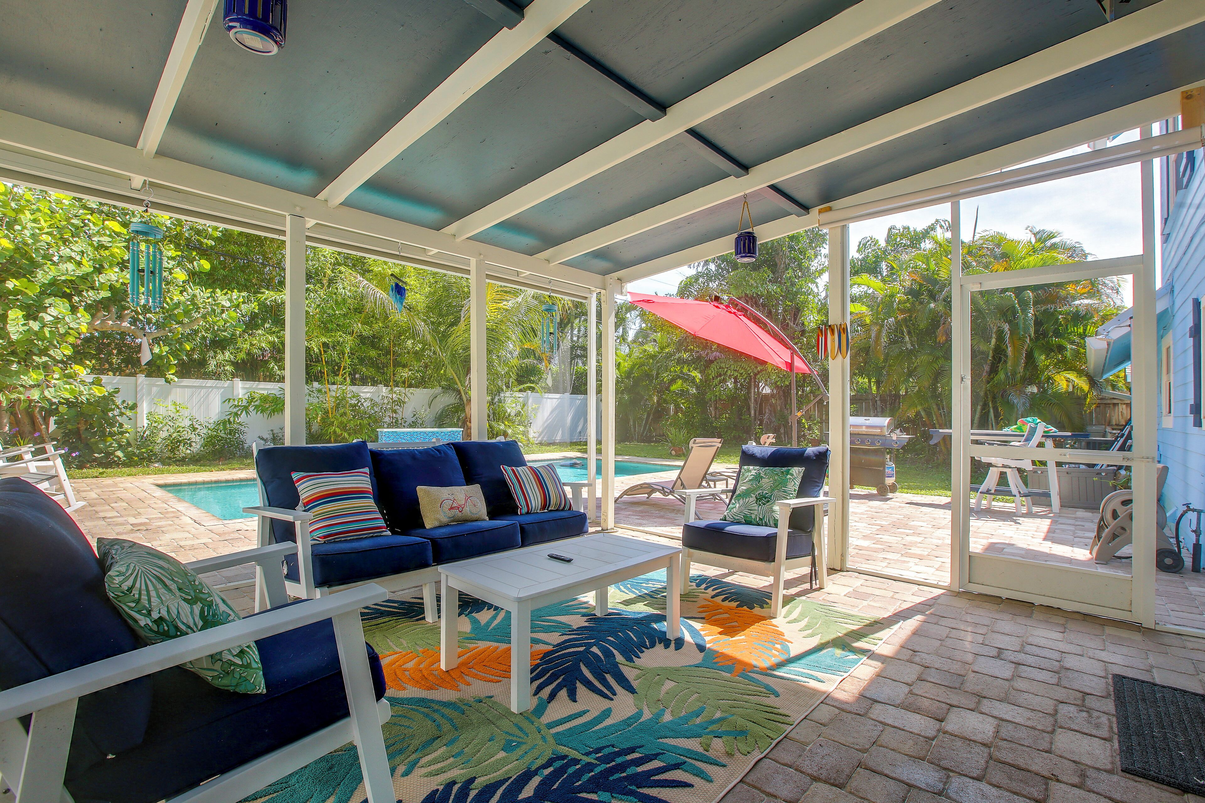 A covered patio with a pool, outdoor furniture, and a view of the backyard.