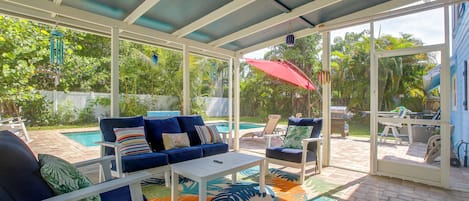 A covered patio with a pool, outdoor furniture, and a view of the backyard.
