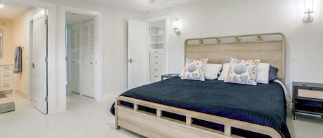 Ein Schlafzimmer mit einem Bett, einem Deckenventilator, einem Nachttisch und einem Fernsehschrank.