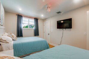 A bedroom with two beds, a television on the wall, and a window with curtains. - Delray Beach Oasis! Screened Lanai & Private Pool (Delray Beach)