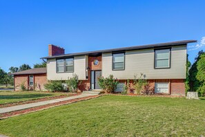 A two-story house with a front porch, a brick chimney, and a well-maintained lawn. - Centrally Located Escape in Midvale w/ Yard! (Midvale)