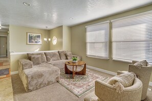 A living room with a sectional sofa, a round coffee table, and a patterned rug. - Centrally Located Escape in Midvale w/ Yard! (Midvale)