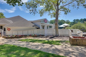 A building with a white picket fence, a tennis court sign, and a sign for 'The Mill Coffee & Sweets.' - Condo Close to Busch Gardens/Colonial Williamsburg (Williamsburg)