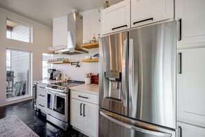 Een moderne keuken met roestvrijstalen apparatuur, witte kasten en een ingebouwde oven.