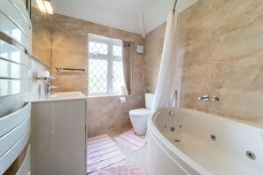 A bathroom with a bathtub, toilet, and sink.