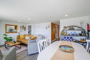 A living room with a sofa, a dining table, and a kitchen area with a wine rack. - Direct Beach Access, 2 Mi to Chinook Winds Casino (Lincoln City)